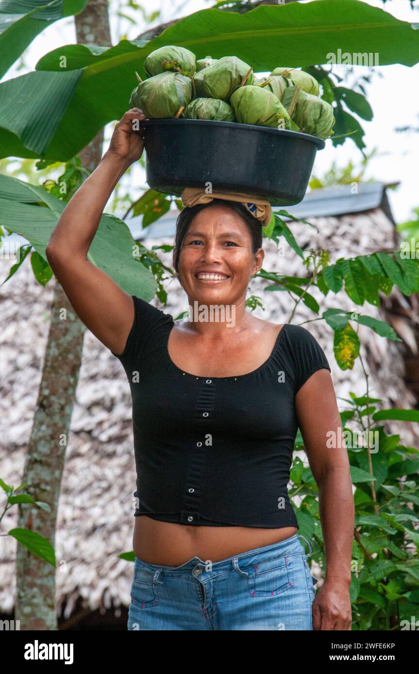 Woman selling Juanes homemade corn and chicken tamales by traditional method in Timicuro I, Iqutios peruvian amazon, Loreto, Peru. Stock Photo