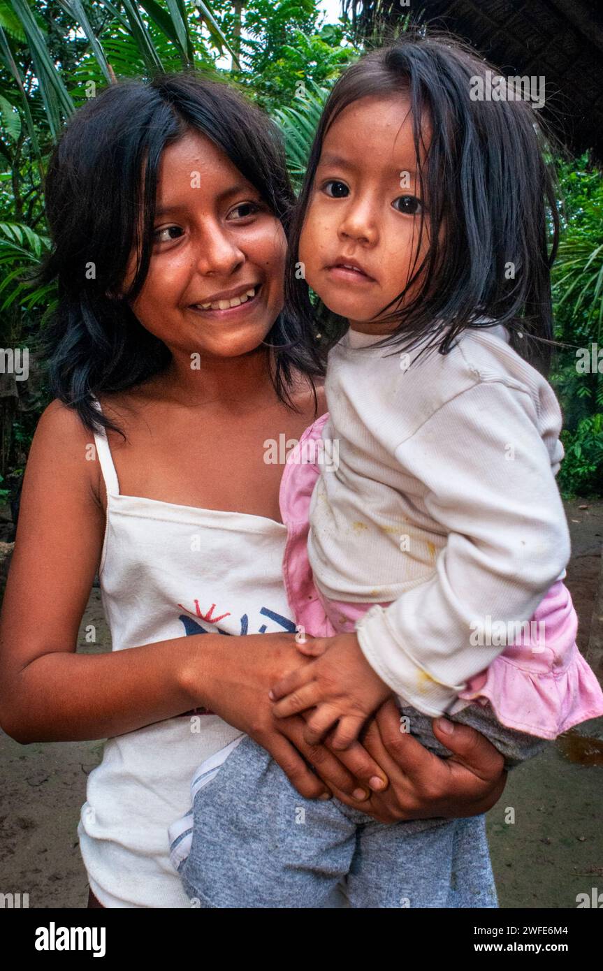 A girl takes care of her sister while her parents work, local family in the riverside village of Timicuro I. Iqutios peruvian amazon, Loreto, Peru Stock Photo