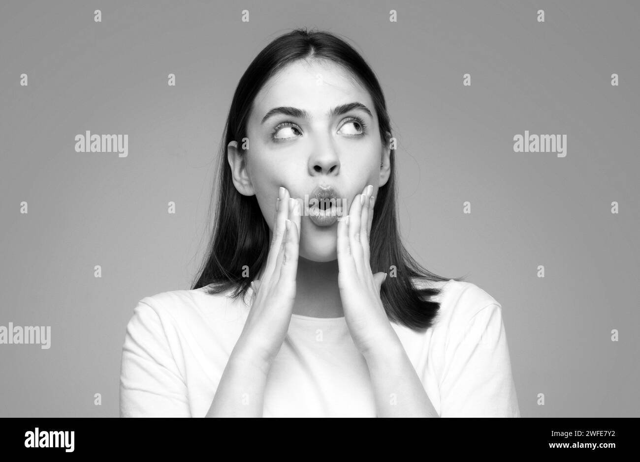 Shocked face of surprised young woman. Funny female shocked face expression. Unbelievable. Portrait of excited woman spreading hands. Expressing Stock Photo