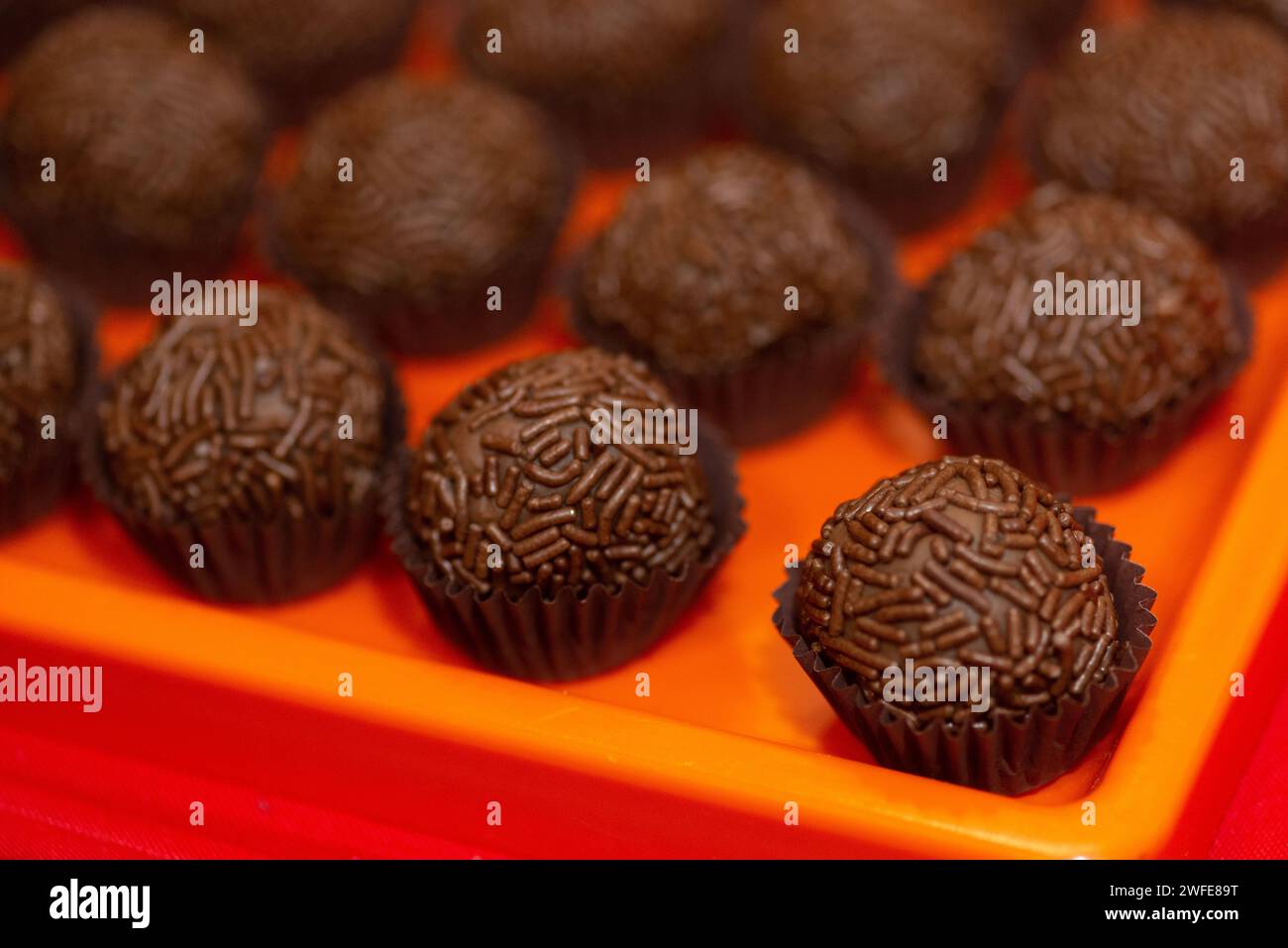 Assorted chocolates showcased on a vibrant red table Stock Photo