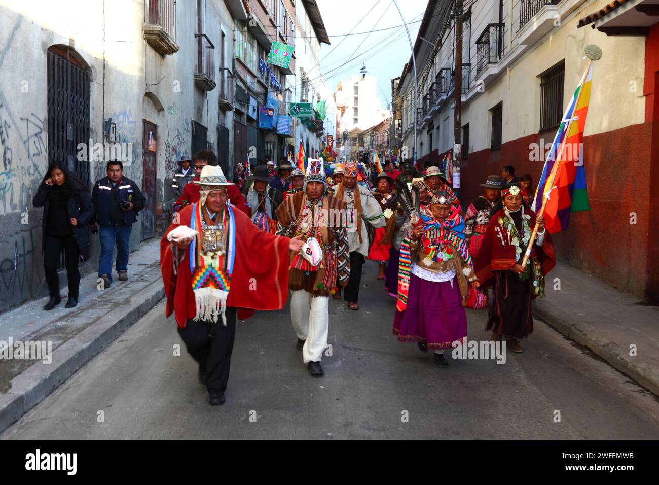 La Paz, BOLIVIA; 24th January 2015. Aymara shamans carrying conch shells walks in front of an ancient illa (or statue) of an Ekeko (an Aymara god of abundance) as it is paraded through the streets of La Paz to celebrate its first appearance at the Alasitas festival, which starts today. The statue is around 2000 years old and was made by the Pucara culture. It was taken from the archaeological site of Tiwanaku to Switzerland in 1858, and returned to Bolivia by the Berne History Museum in November 2014. Stock Photo