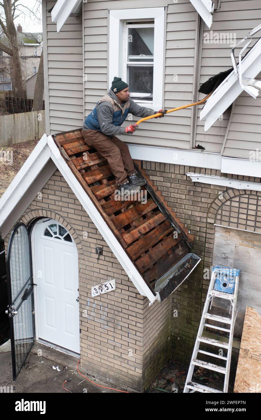 Detroit, Michigan - Workers replace a roof on a vacant house in the Morningside neighborhood. They were part of an effort by a nonprofit, the U Snap B Stock Photo
