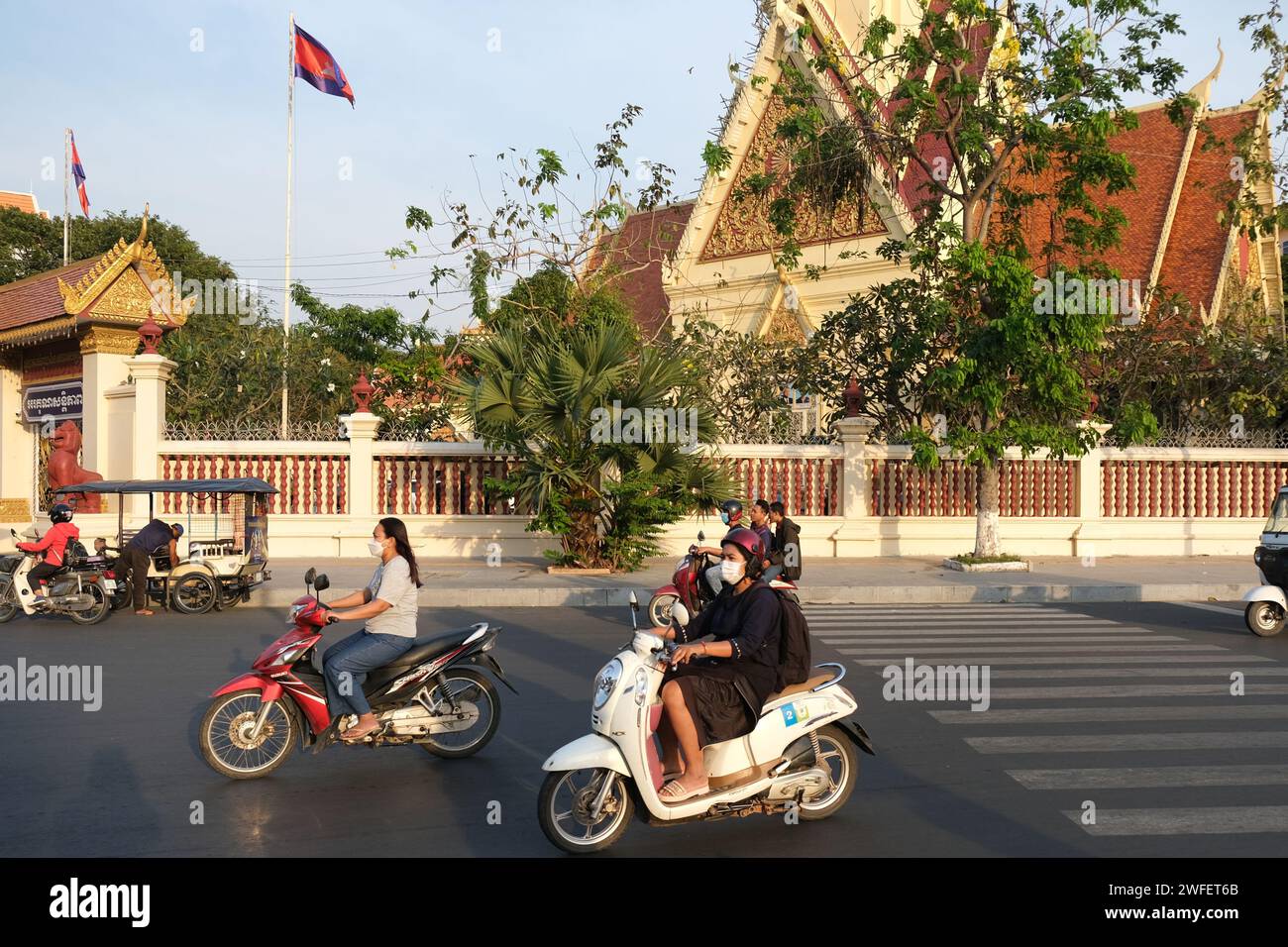 Women ride scooters outside Cambodia's supreme court in Phnom Penh Stock Photo