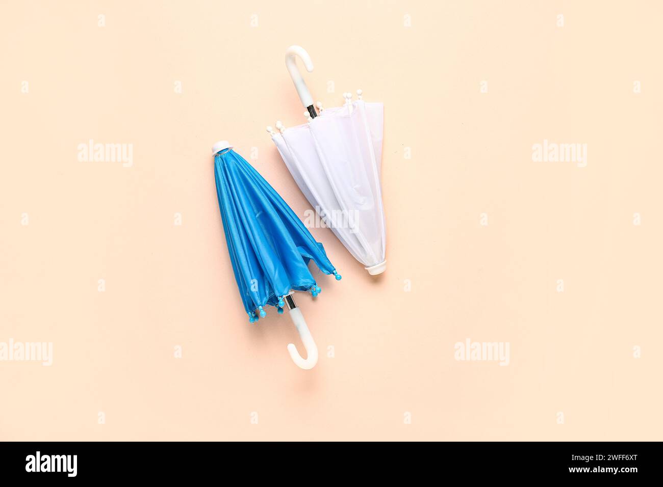 Mini stylish umbrellas on beige background Stock Photo