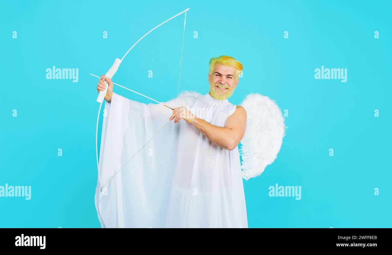 Happy Valentines day. Bearded man in angel wings with bow and arrow. Valentine cupid aiming with bow. Male Valentines angel costume shoots arrow of Stock Photo