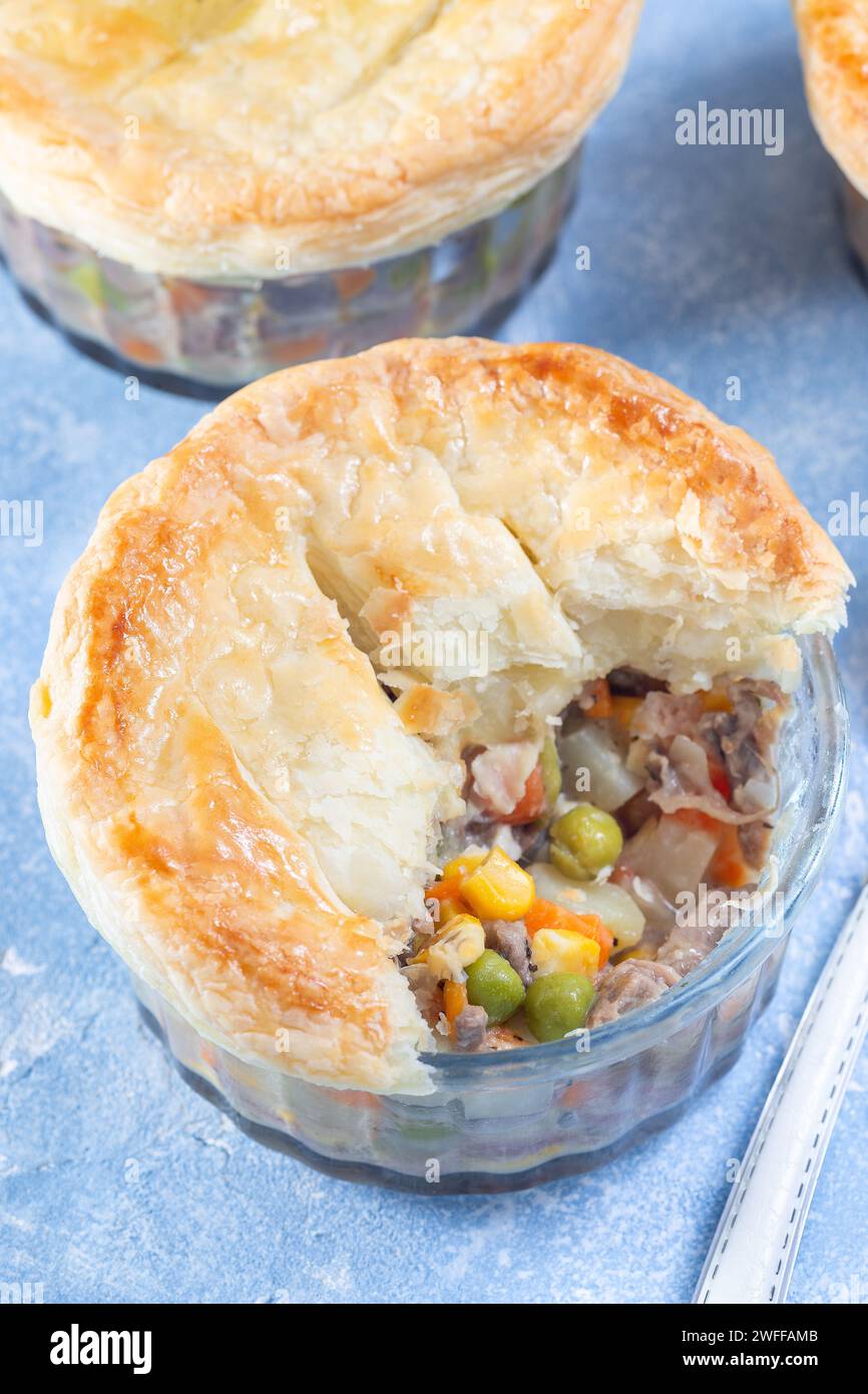 Individual beef pot pies or deep dish pies in ramekin, crust broken