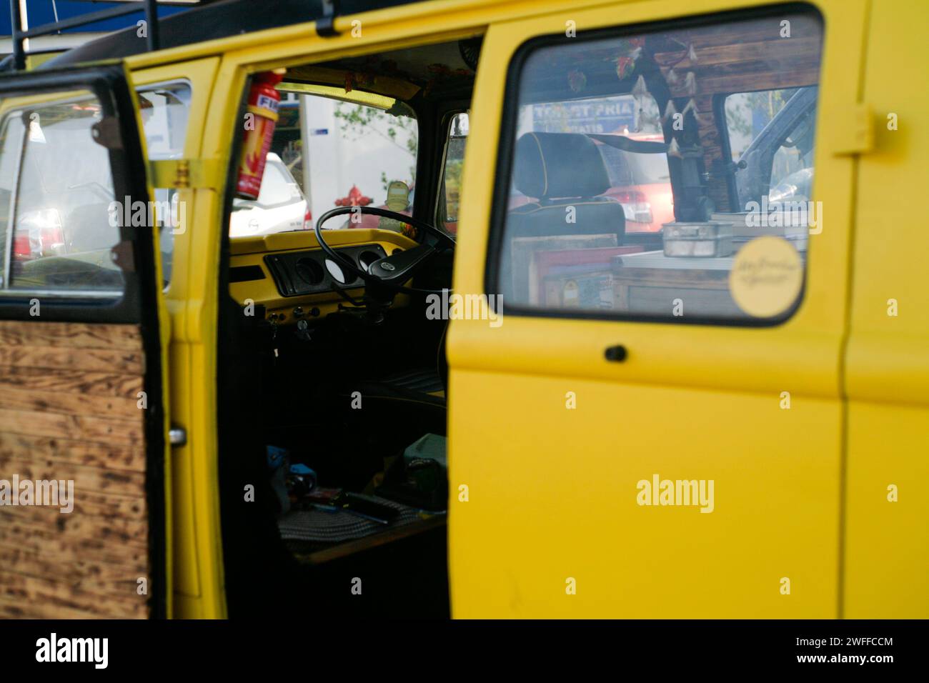 Yellow Volkswagen kombi or bus parked in the side road Stock Photo