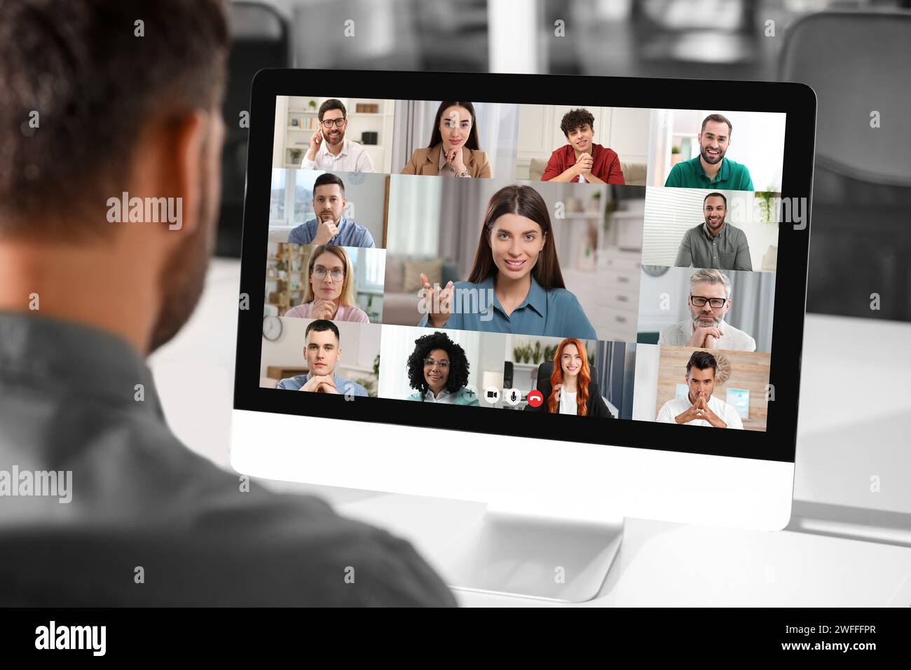 Man having video chat with coworkers at office Stock Photo