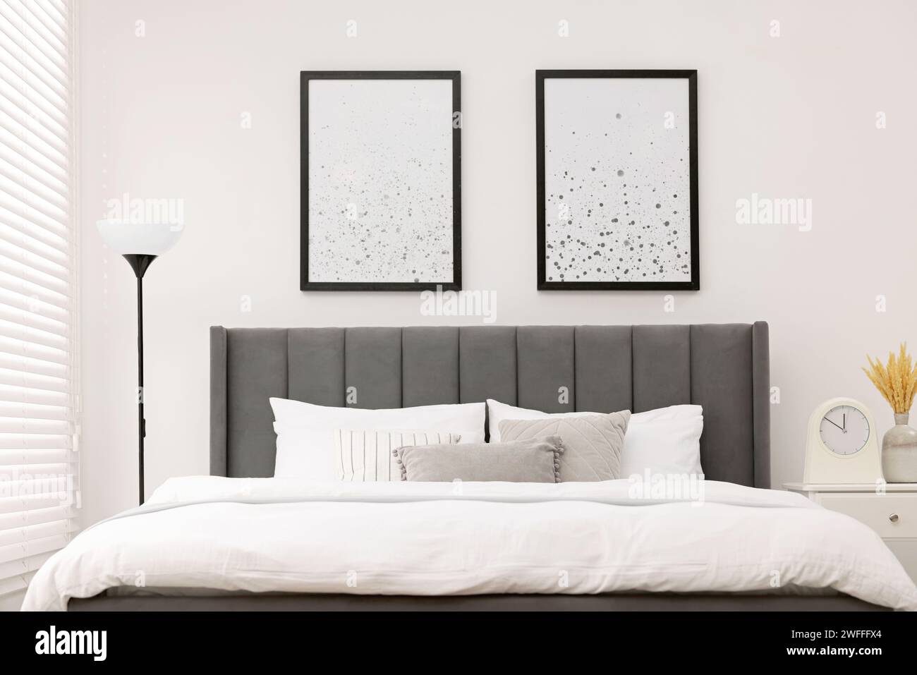 Large bed, bedside table and lamp in stylish bedroom. Interior design