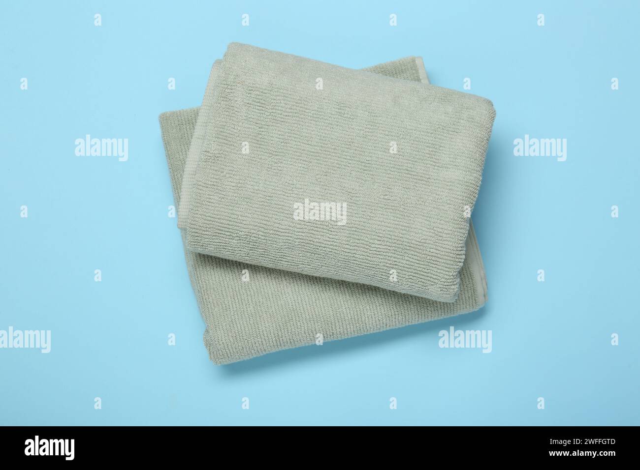 Folded terry towels on light blue background, top view Stock Photo