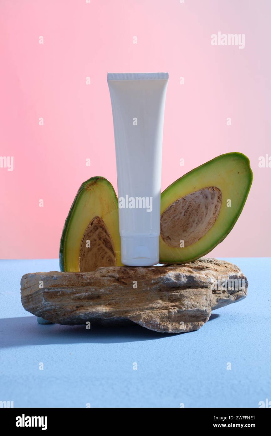 A white tube pouted on a stone with Avocado slices. Branding mockup