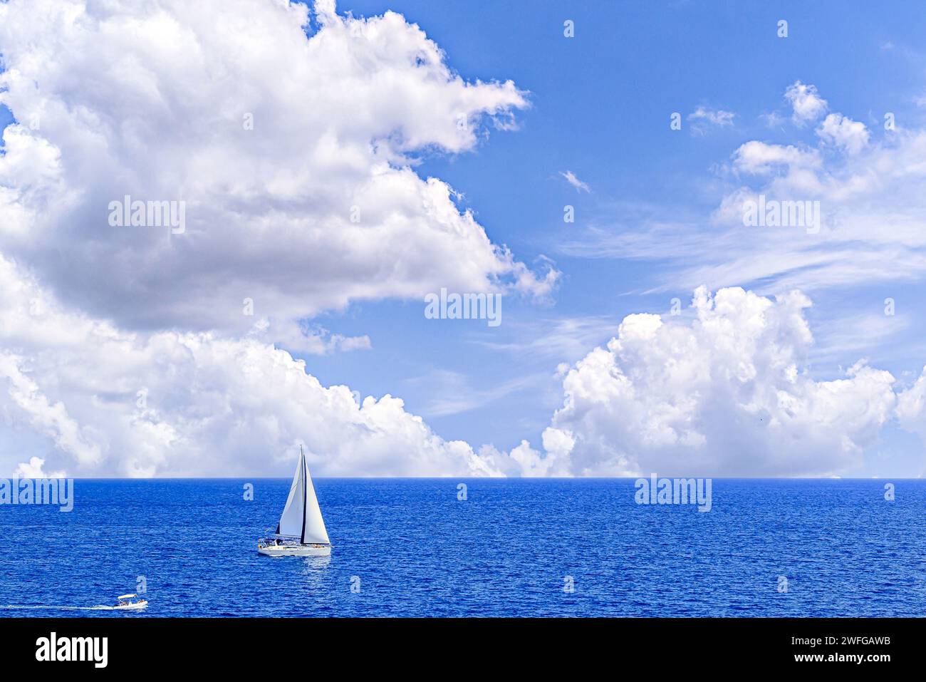 Boat, sailboat sailing on the beach of Mallorca under a blue sky with white clouds Stock Photo
