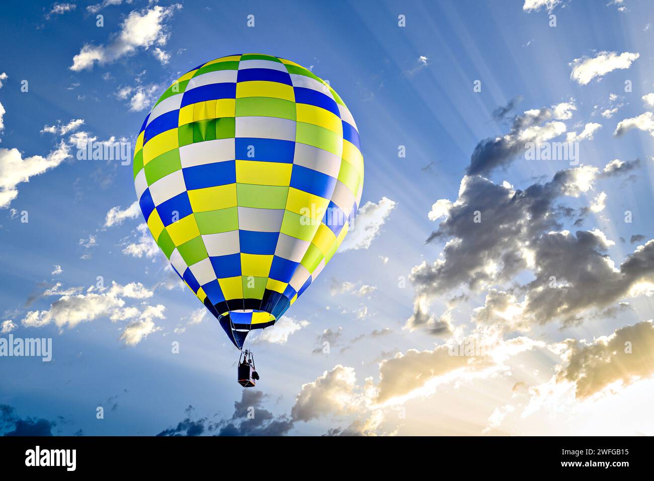 Colorful hot air balloon flying over blue sky with white clouds Stock ...