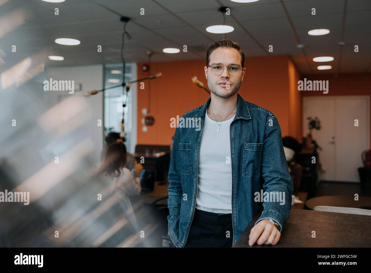 Portrait of confident young businessman standing in office Stock Photo