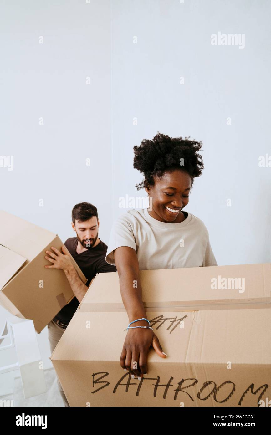 Multiracial couple carrying cardboard boxes at home Stock Photo