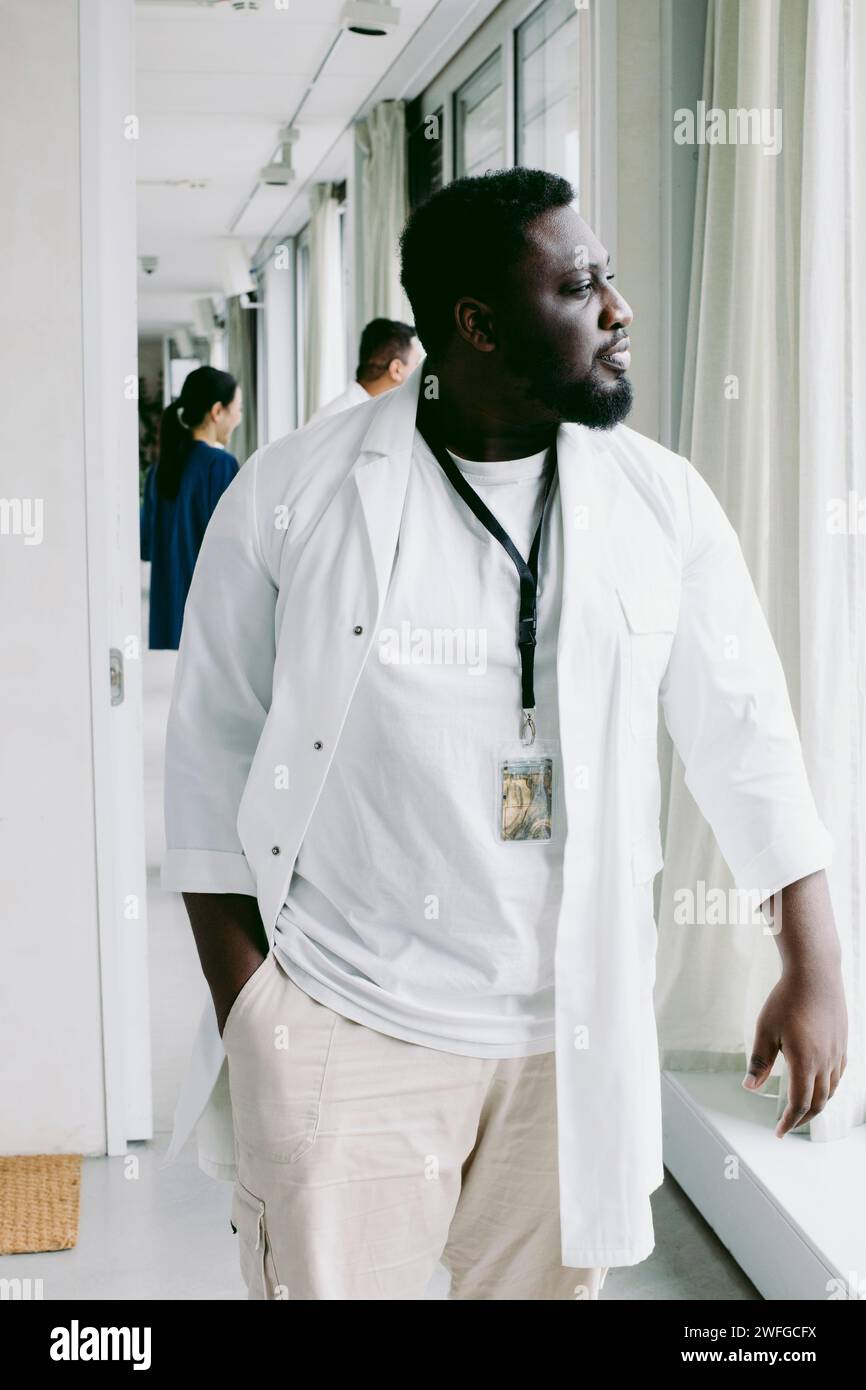 Young male doctor walking at hospital corridor Stock Photo