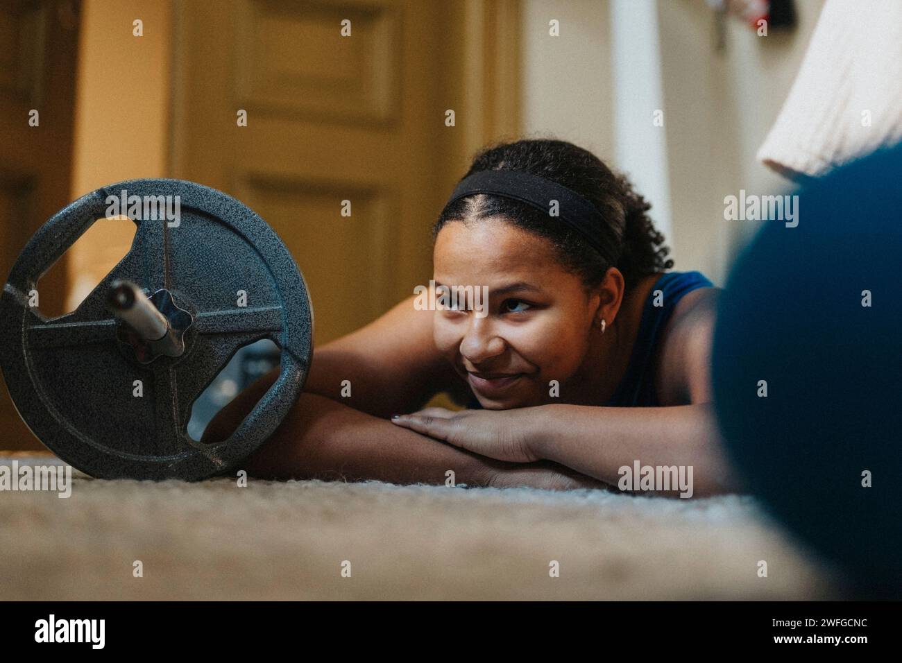 Smiling teenage girl lying on carpet at home Stock Photo - Alamy