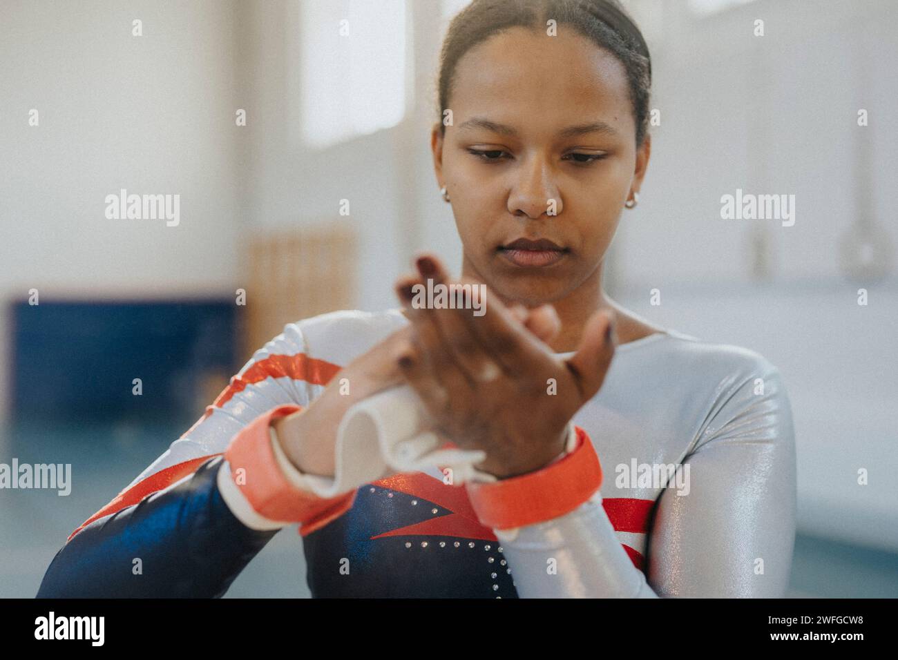 Teenage girl applying chalk powder on hands at gym Stock Photo Alamy