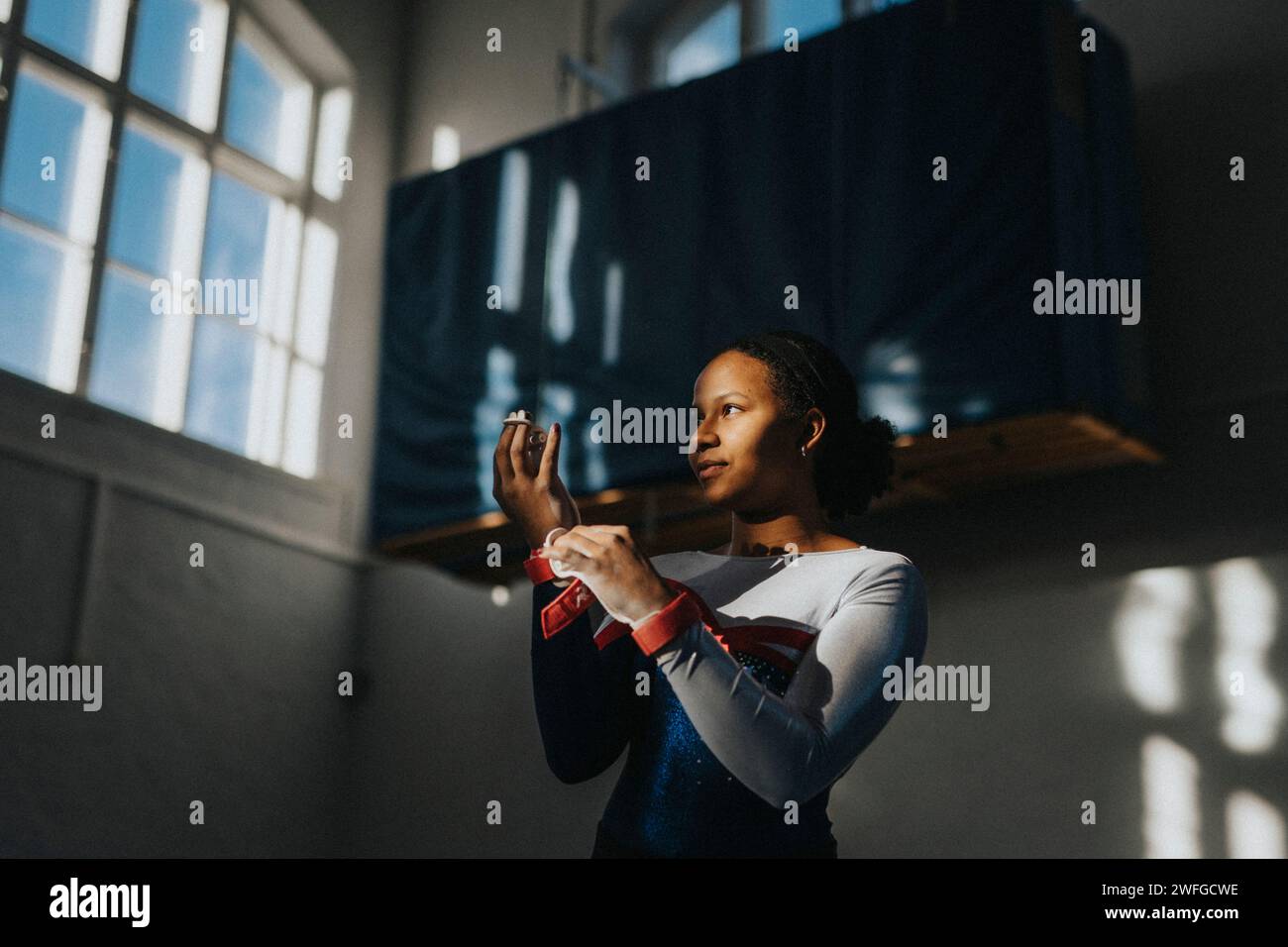 Contemplative teenage girl standing in school gymnasium Stock Photo