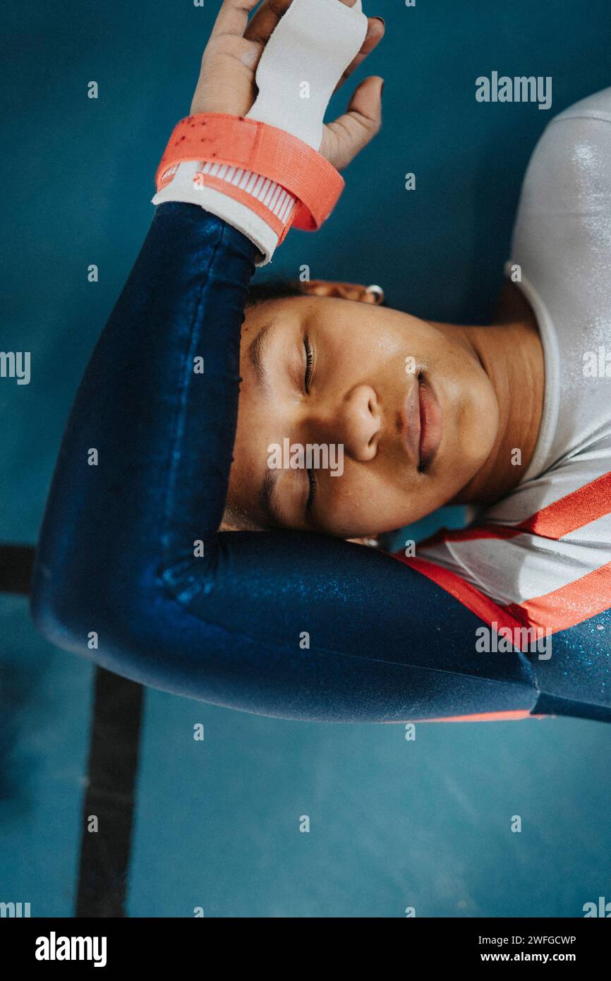 Directly above shot of female athlete with eyes closed resting on floor Stock Photo