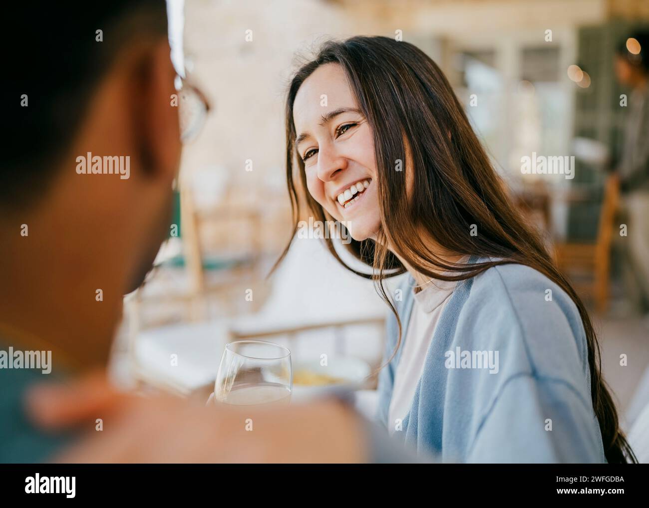 Smiling young woman talking with man sitting in patio Stock Photo