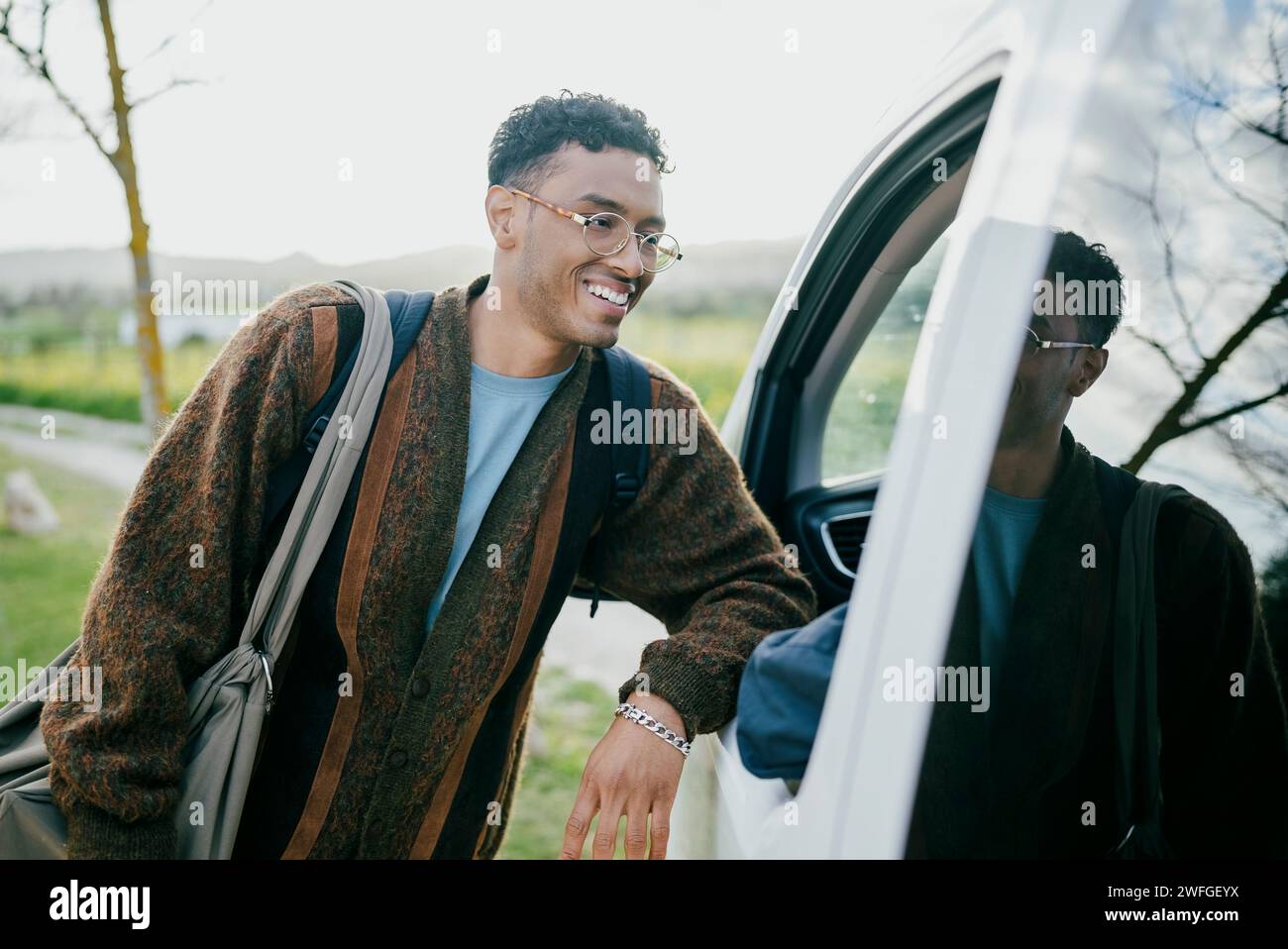 Smiling young man leaning van Stock Photo
