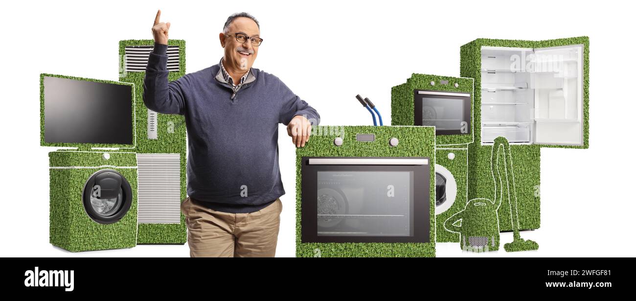 Mature man pointing up and standing next to green energy efficient appliances isolated on white background Stock Photo