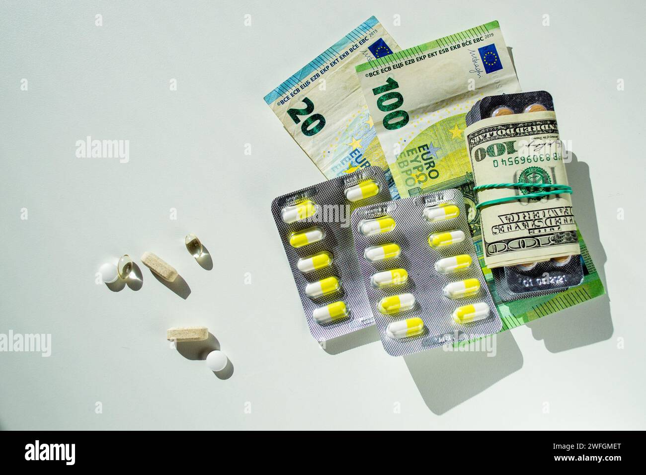 Medicinal tablets and capsules. Banknotes as the cost of manufacturing medicines Stock Photo Alamy