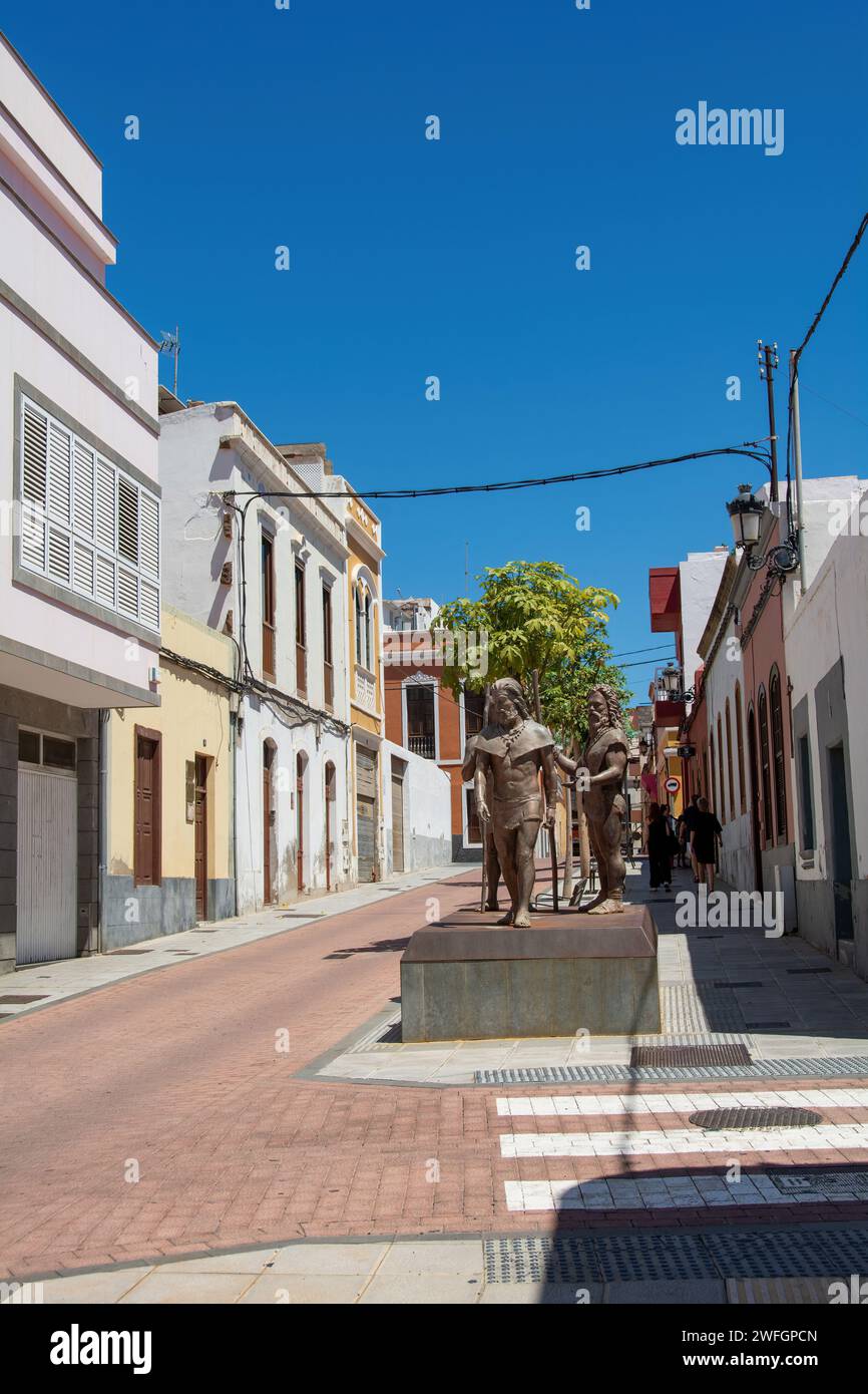 A street with houses and with sculptures in the old town of Galdar on the Canary Island of Gran Canaria in Spain Stock Photo