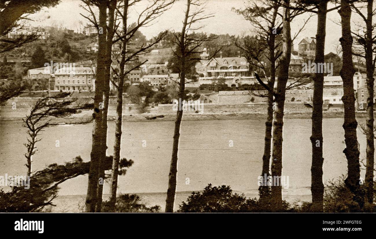 Photograph of Salcombe waterfront from across the mouth of the Kingsbridge Estuary, in the South Hams district of Devon - a resort town -  has a traditional shellfish fishing industry - now a second home hotspot.. From the book Glorious Devon. by S.P.B. Mais, published by London Great Western Railway Company, 1928 Stock Photo