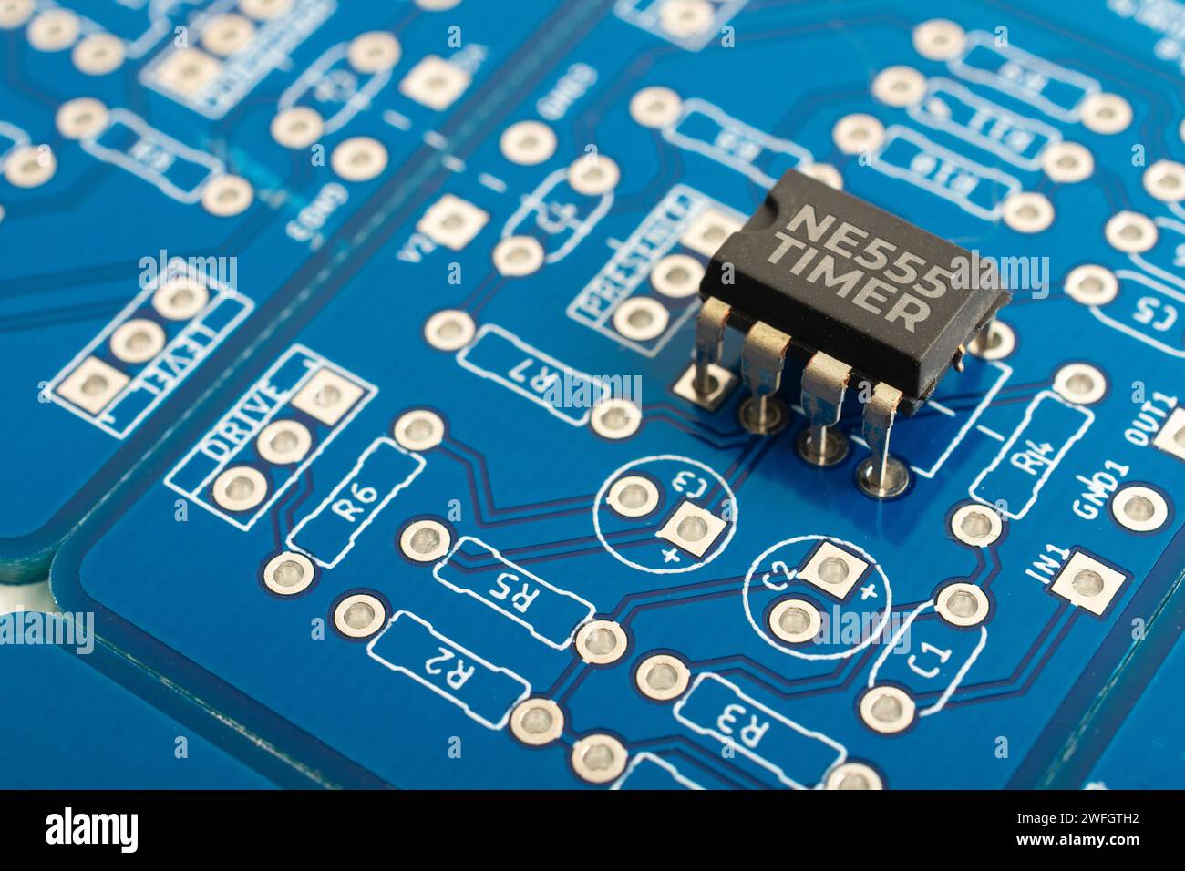 NE555 timer integrated circuit on a blue pcb Stock Photo