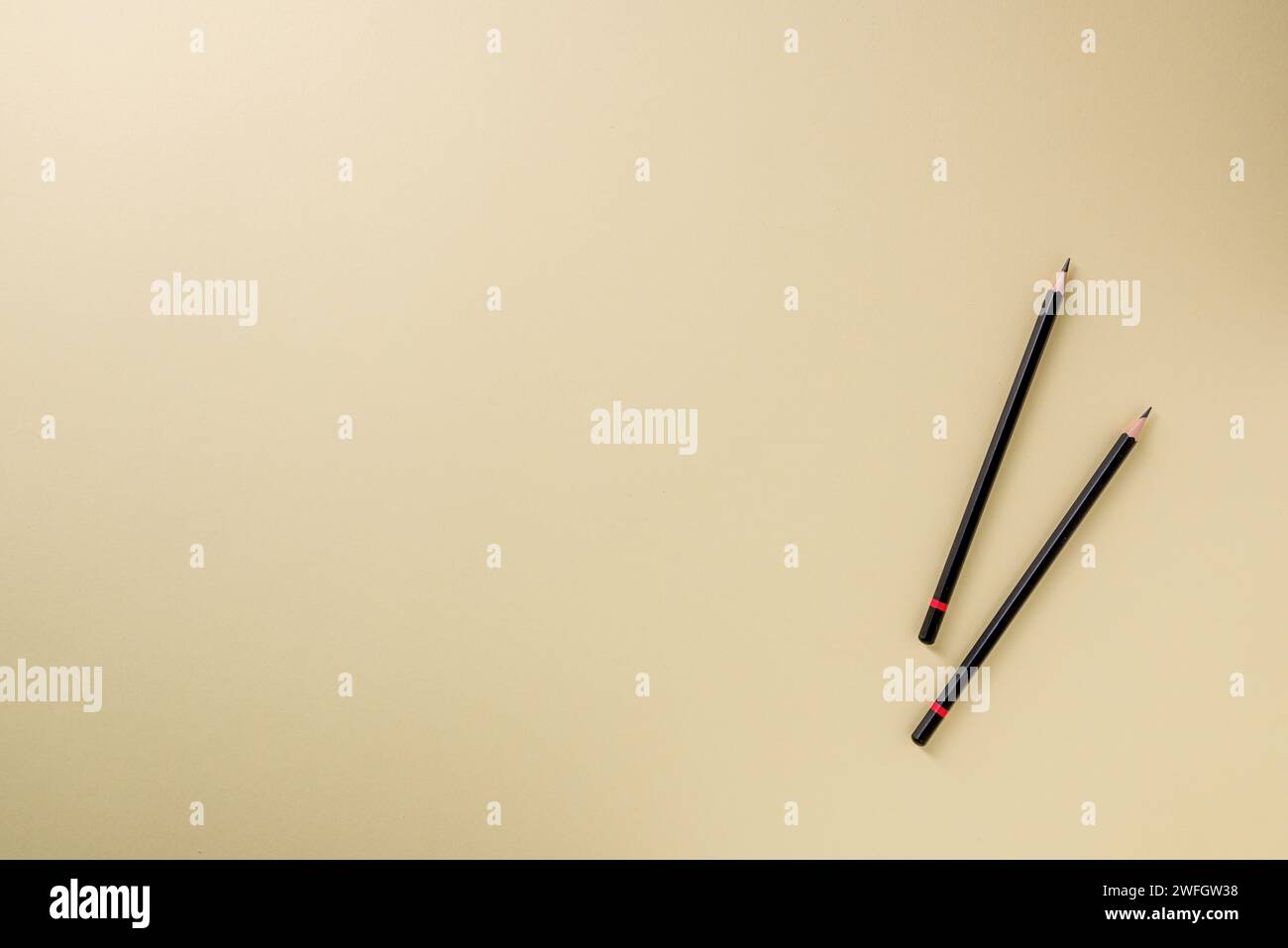 Pencil with black paint and a red stripe on a yellow background Stock Photo