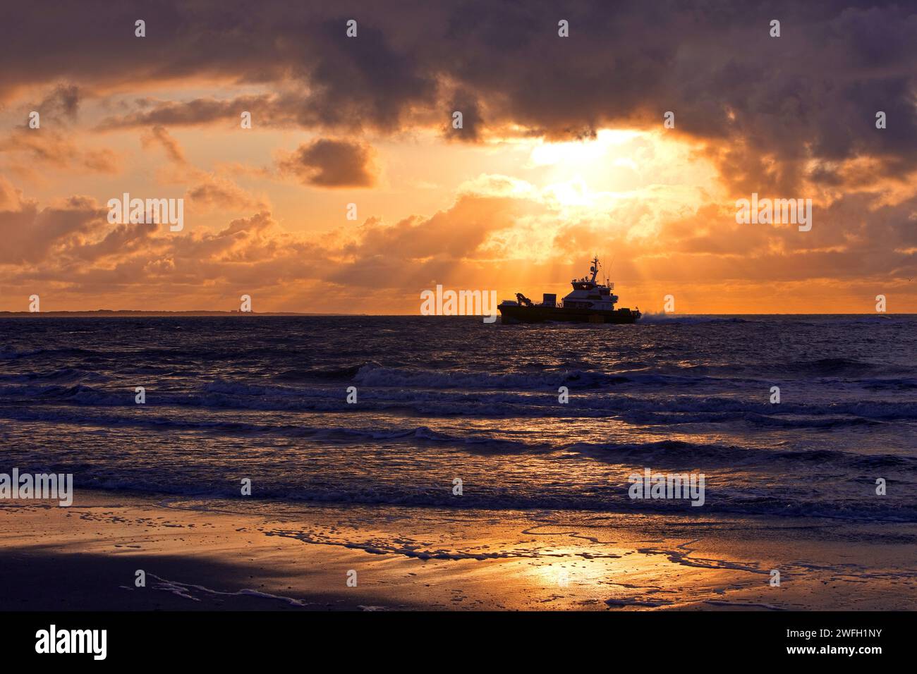 Sea at sunset with the offshore supply vessel FARRA CLIONA, Germany, Lower Saxony, Norderney Stock Photo