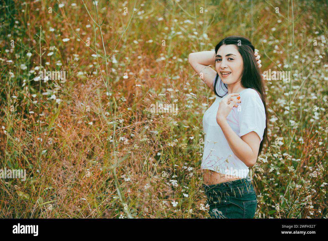 Beautiful young woman standing in the field Stock Photo