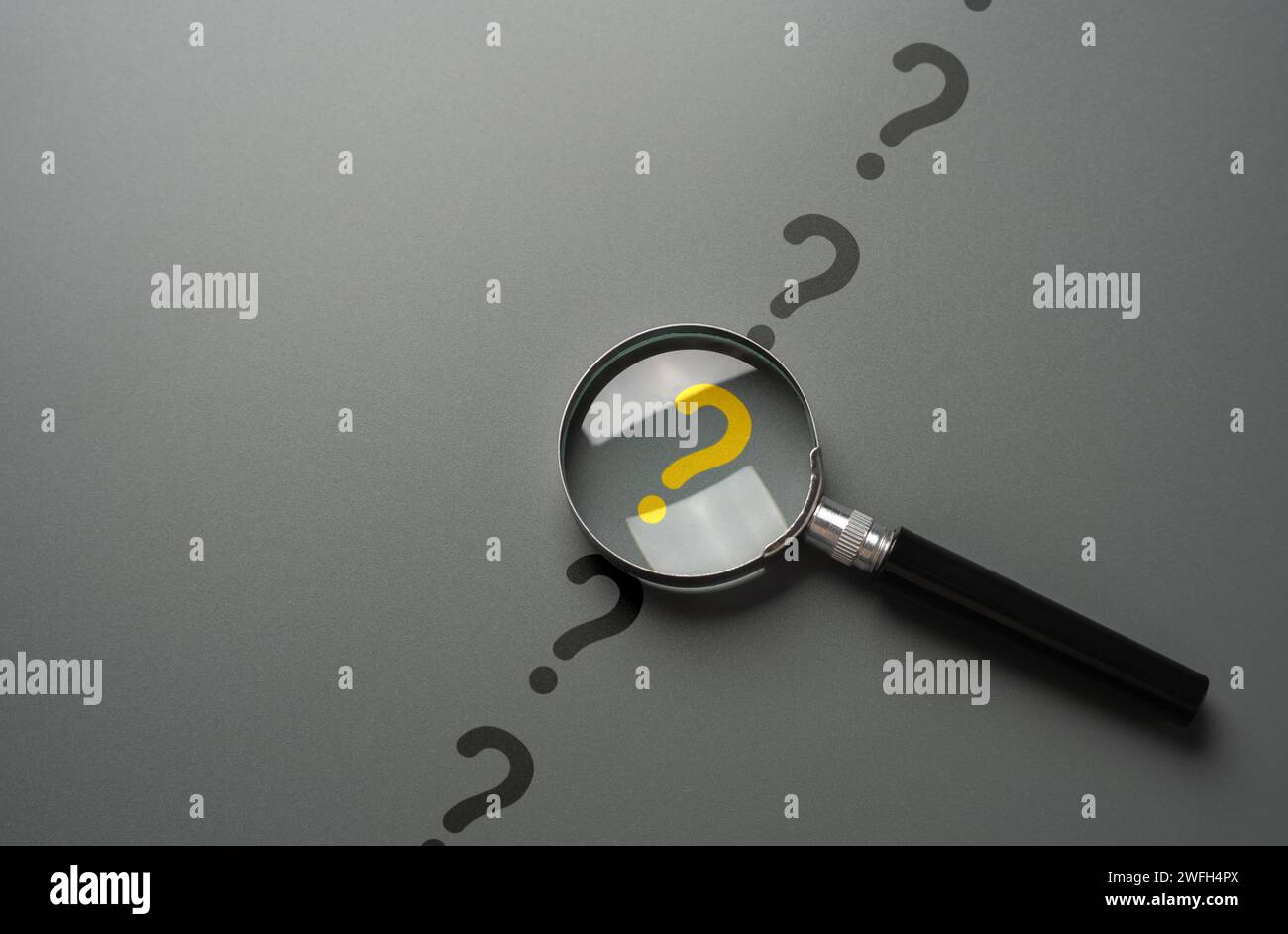 Magnifying glass and yellow question mark. FAQ. Solving mysteries