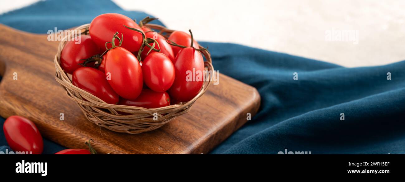 Fresh cherry tomatoes in a plate over white table background Stock Photo