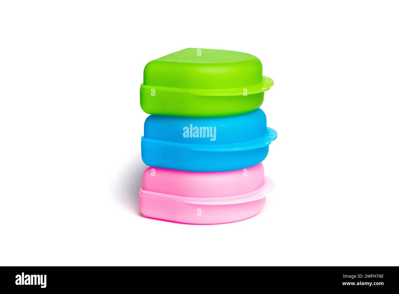 Colorful plastic box package isolated on white background. Green, blue and pink case Stock Photo