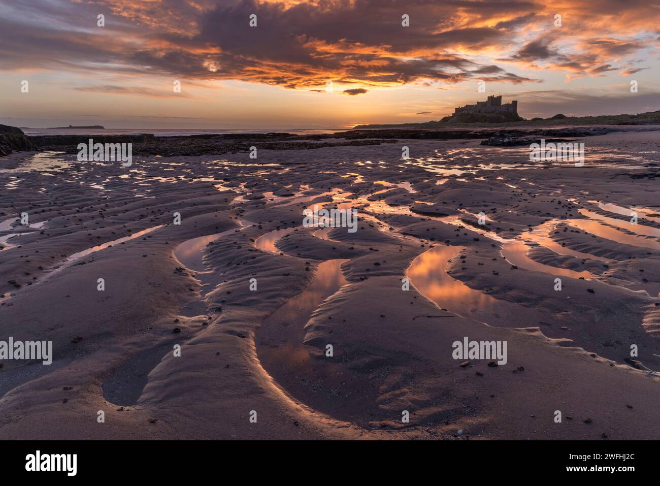 Sunrise at Bamburgh Castle, Bamburgh Beach, Northumberland, UK Stock Photo