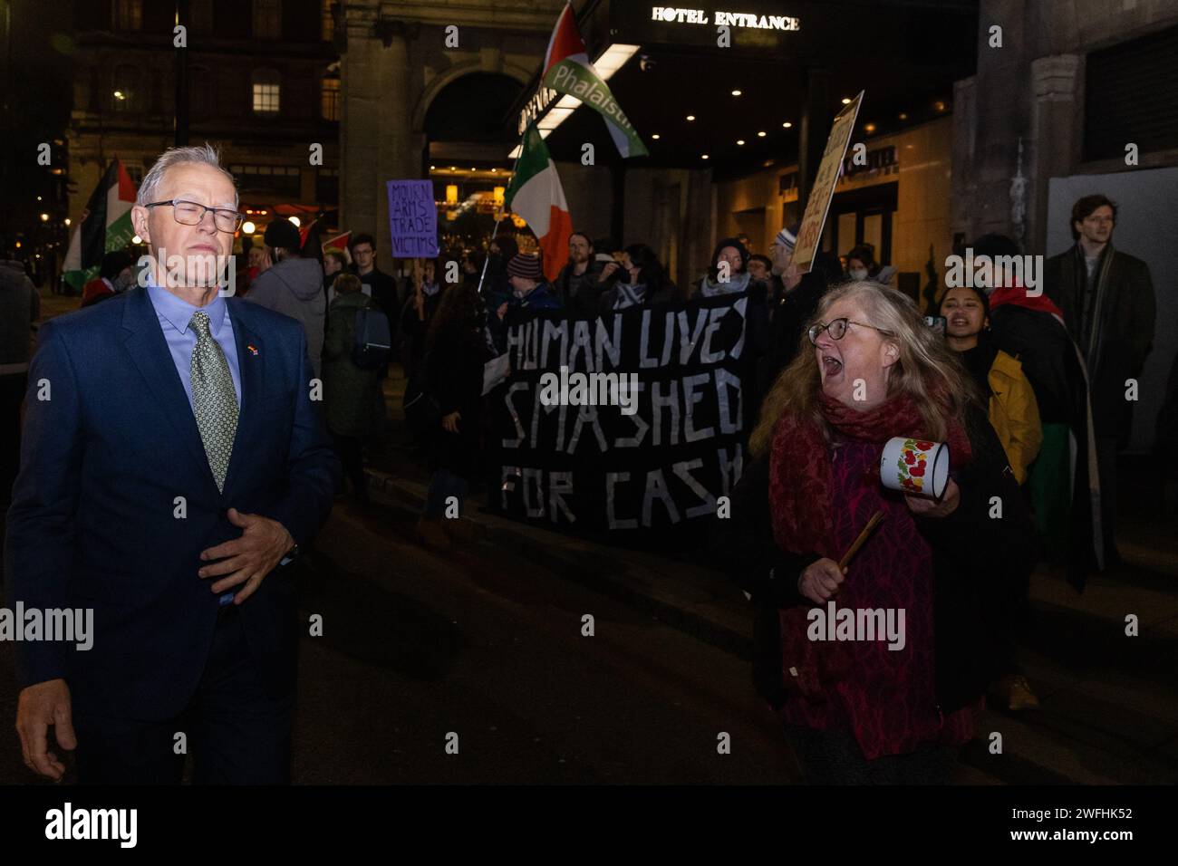 London, UK. 30th January, 2024. A guest arriving at the JW Marriott Grosvenor House Hotel for the ADS Annual Dinner encounters a protest by campaigners against the arms trade. The ADS Annual Dinner brings together representatives of companies from the UK's aerospace, defence, security and space industries. Sponsors of the event include BAE Systems which supplies components for F-35 combat aircraft used by Israel during its invasion of Gaza. Credit: Mark Kerrison/Alamy Live News Stock Photo
