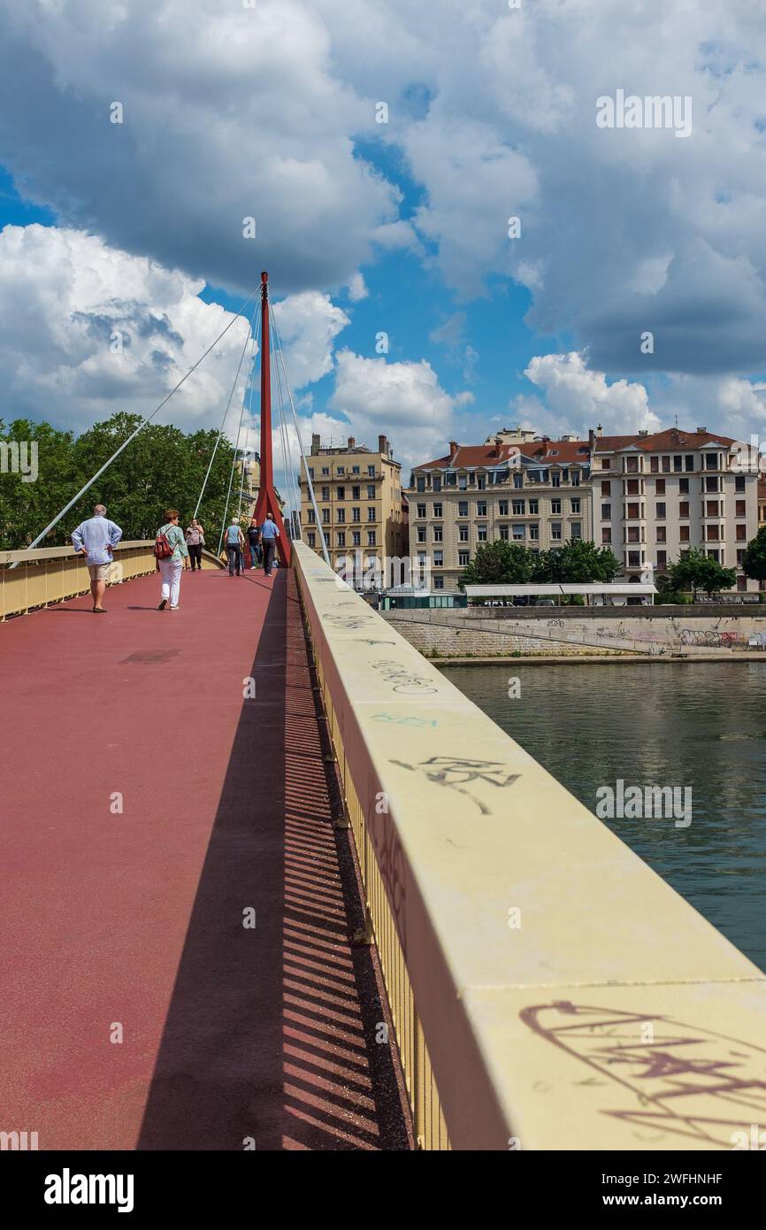 Lyon, France, 2023. People crossing the Palais de Justice bridge, with ...