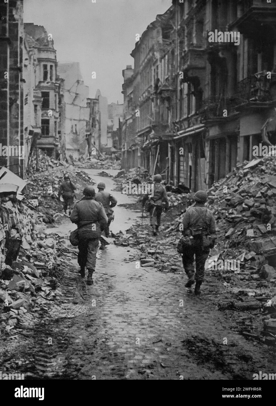 American troops patrolling the ruins of Bonn, in the German state of North Rhine-Westphalia, located on the banks of the Rhine. It was taken by the Allies on the 9th March 1945 as the Second World War gradually came to an end. Stock Photo