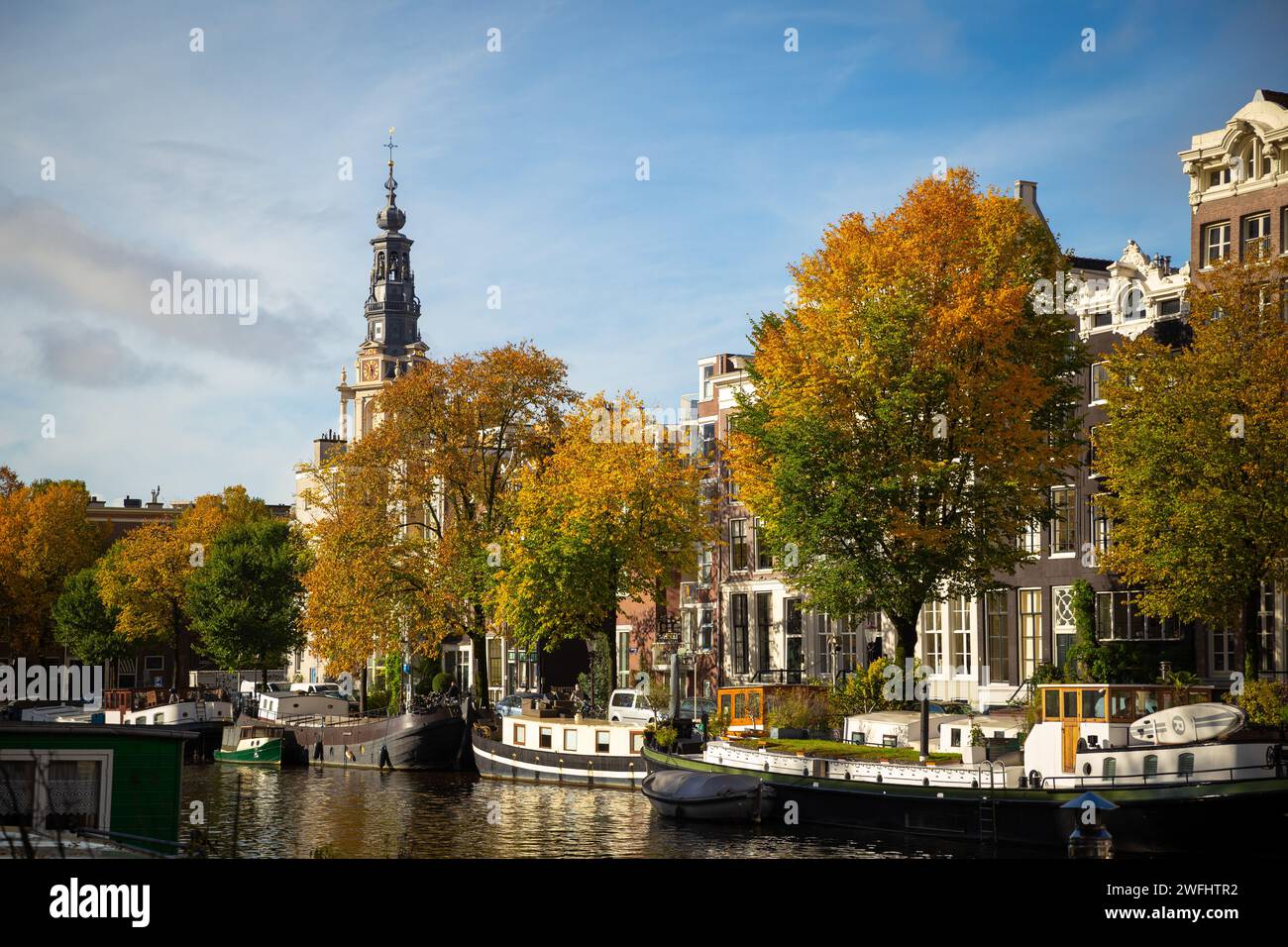 Amsterdam canal and houseboat/ townhouse with autumn colorful trees, Amsterdam Stock Photo