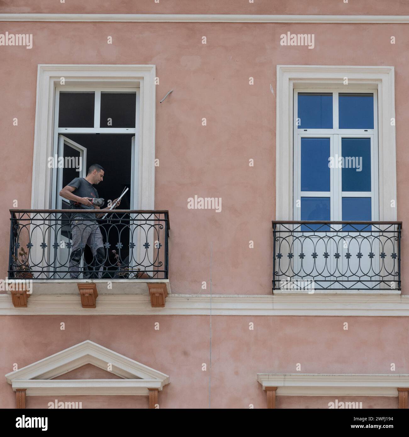 Man standing on a balcony in the City of Cagliari, Sardinia, Italy Stock Photo