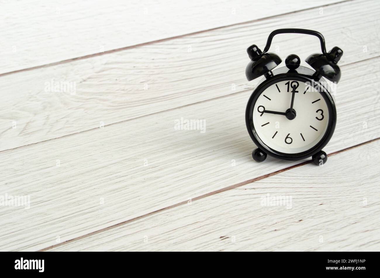 Black table alarm clock with customizable space for text. Time concept and copy space. Stock Photo