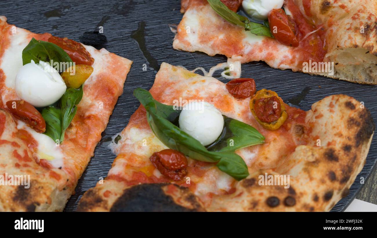 Slices of pizza in a restaurant in the coastal city of Olbia, Northeast Sardinia, Italy Stock Photo