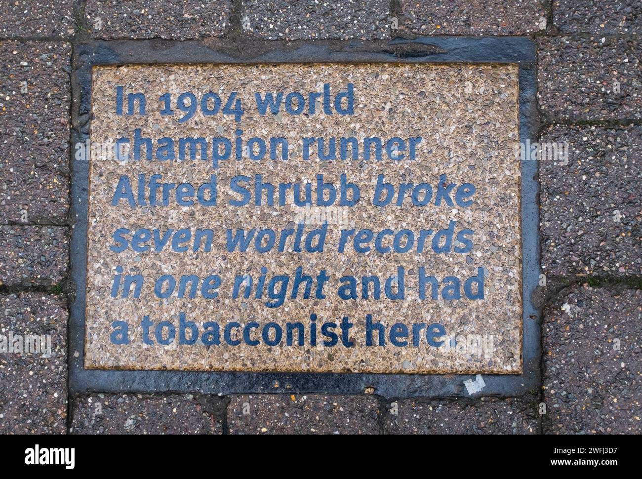 Tourism plaques in the pavement in Middle Street Horsham , West Sussex , England UK . This one celebrating runner Albert Shrubb Stock Photo