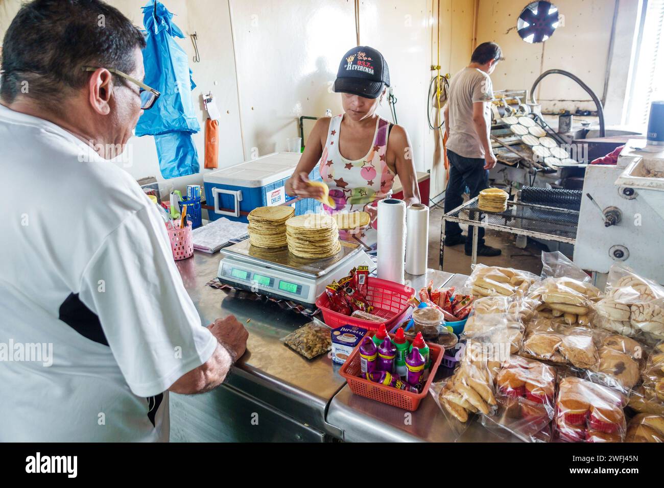Merida Mexico,Zona Paseo Montejo Centro,business inside interior tortillaria tortilla maker making weighing,customer counter buying,man men male,woman Stock Photo
