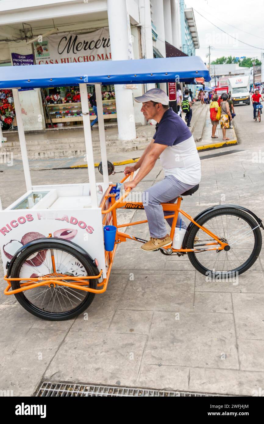 Merida Mexico,centro historico central historic district,Calle 56A,shopping district,man men male,adult adults,resident residents,riding pedaling bike Stock Photo