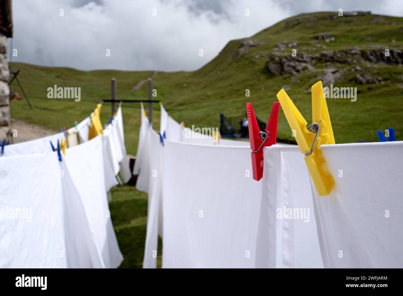 White sheets hang out to dry outside a mountain retreat of the Dolomites mountains Stock Photo