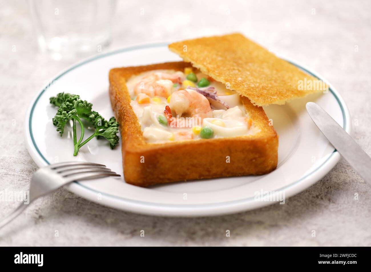 coffin bread, Taiwanese food. It is white bread that has been fried in oil, with the center hollowed out and stuffed with seafood chowder. Stock Photo